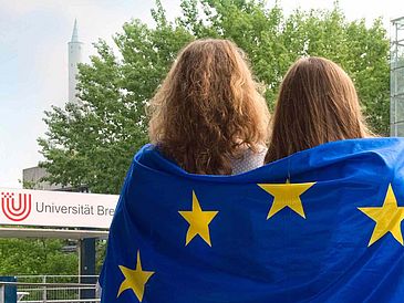 Two women with a European flag can be seen from behind