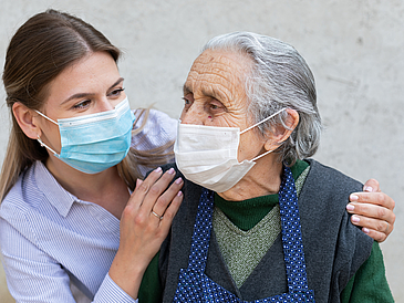Nurse and resident of a nursing home with mouse-nose covering masks
